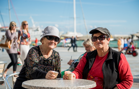 Two solo women travelers enjoy connecting over coffee.